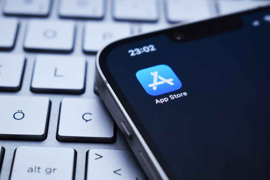 iPhone showing Apple App Store icon on screen, symbolizing apple app store external-payment-links, app compliance, and iOS developer payment options.